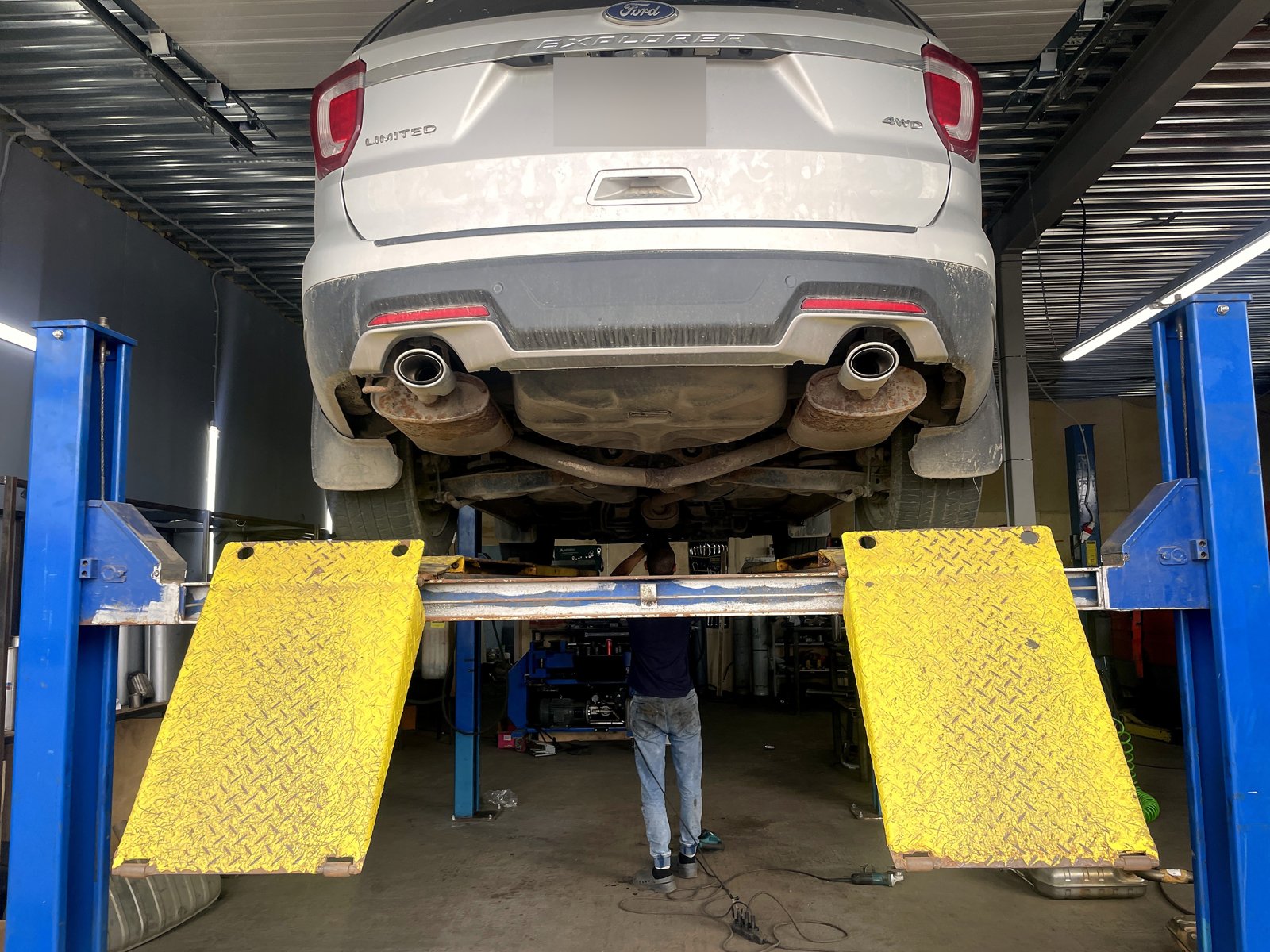 Ford Explorer на подъёмнике сзади после ремонта, номер замазан