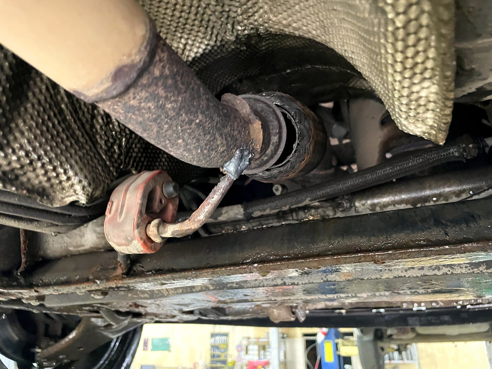 Порванная гофра на красной подушке-держателе снизу Ford Fiesta, оплётка разрушена, край рваный