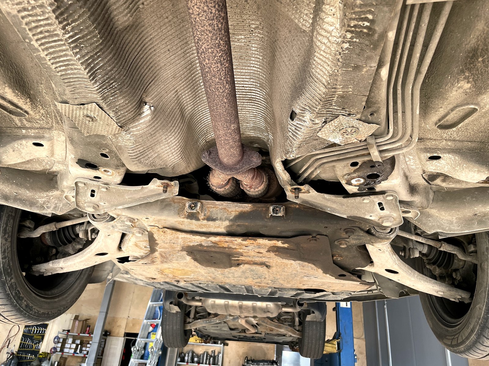 Днище Ford Focus 3 на подъёмнике, приёмная труба уходит в тоннель над подрамником