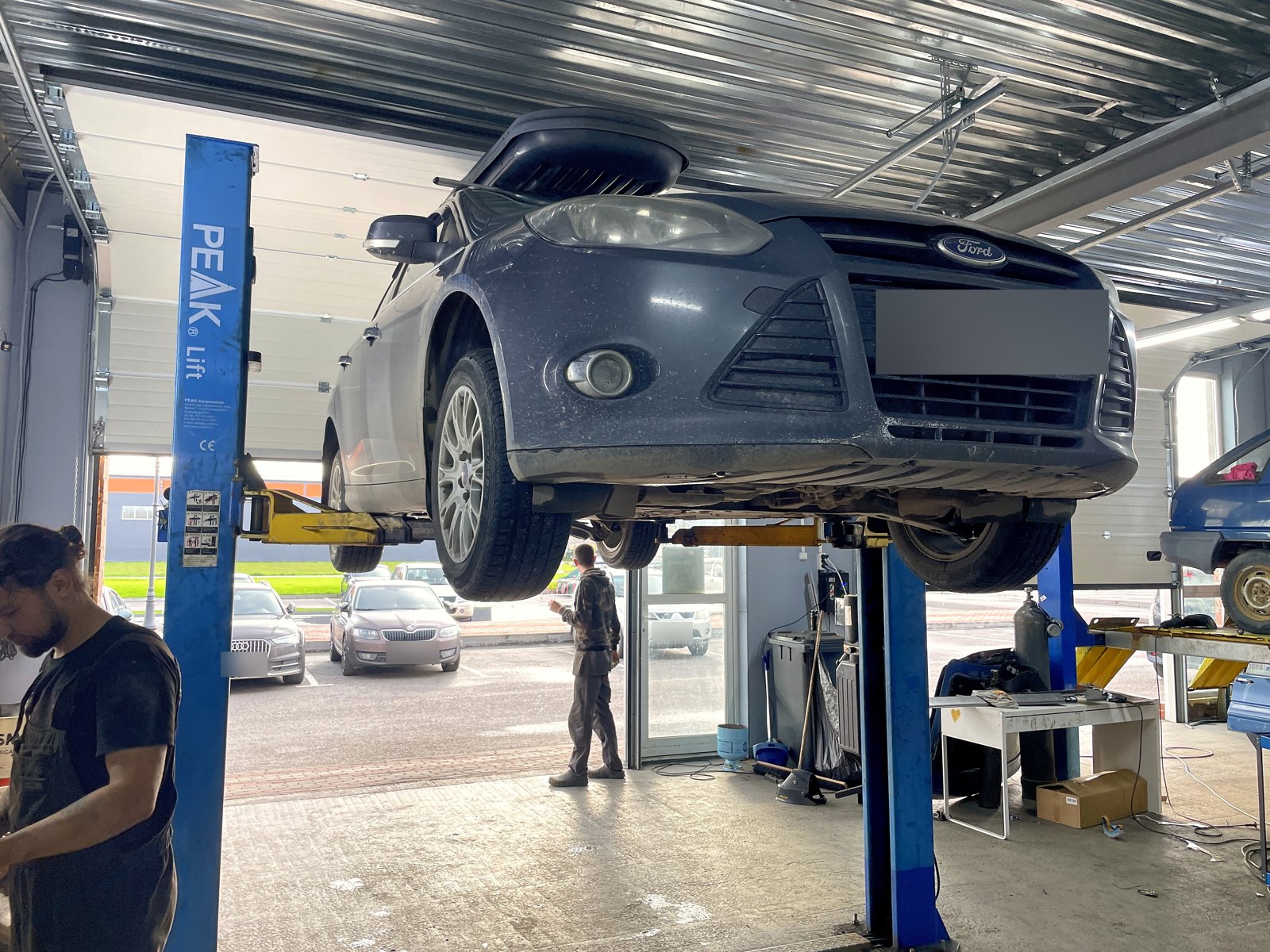 Ford Focus универсал на подъёмнике в боксе «Выхлопухи» в Тельмана, вид спереди снизу, номер замазан