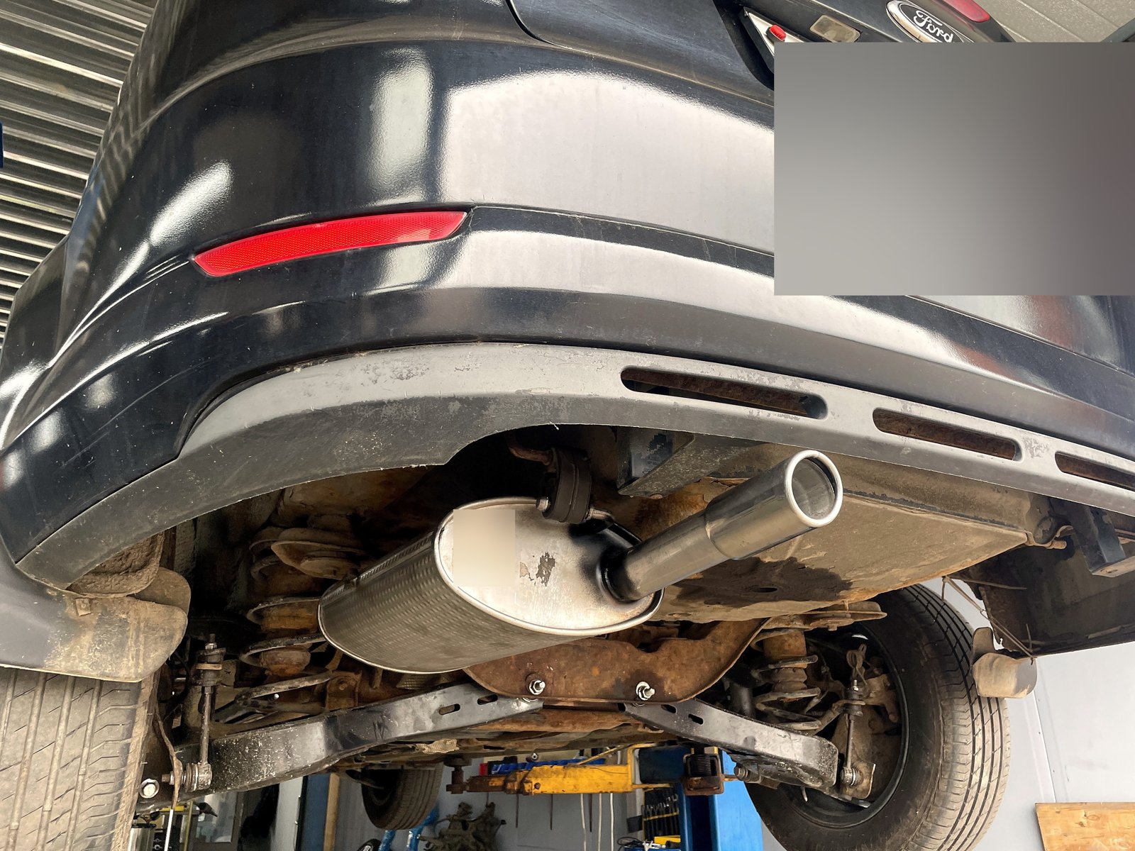 Новая банка с выведенной насадкой на Ford Mondeo 4 после ремонта, вид снизу-сзади