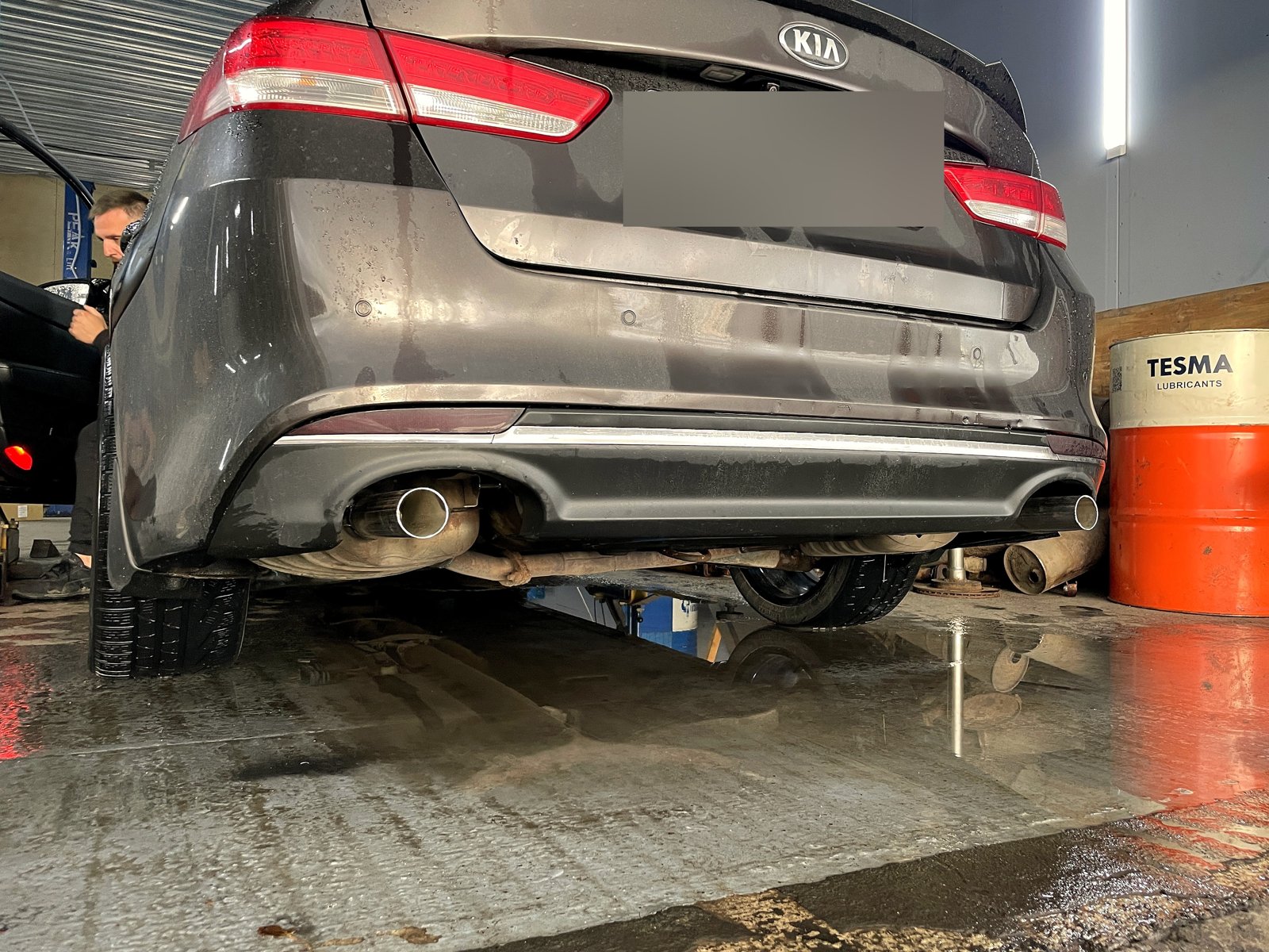 Корма Kia после ремонта, два обычных выхода со светлыми насадками по краям бампера