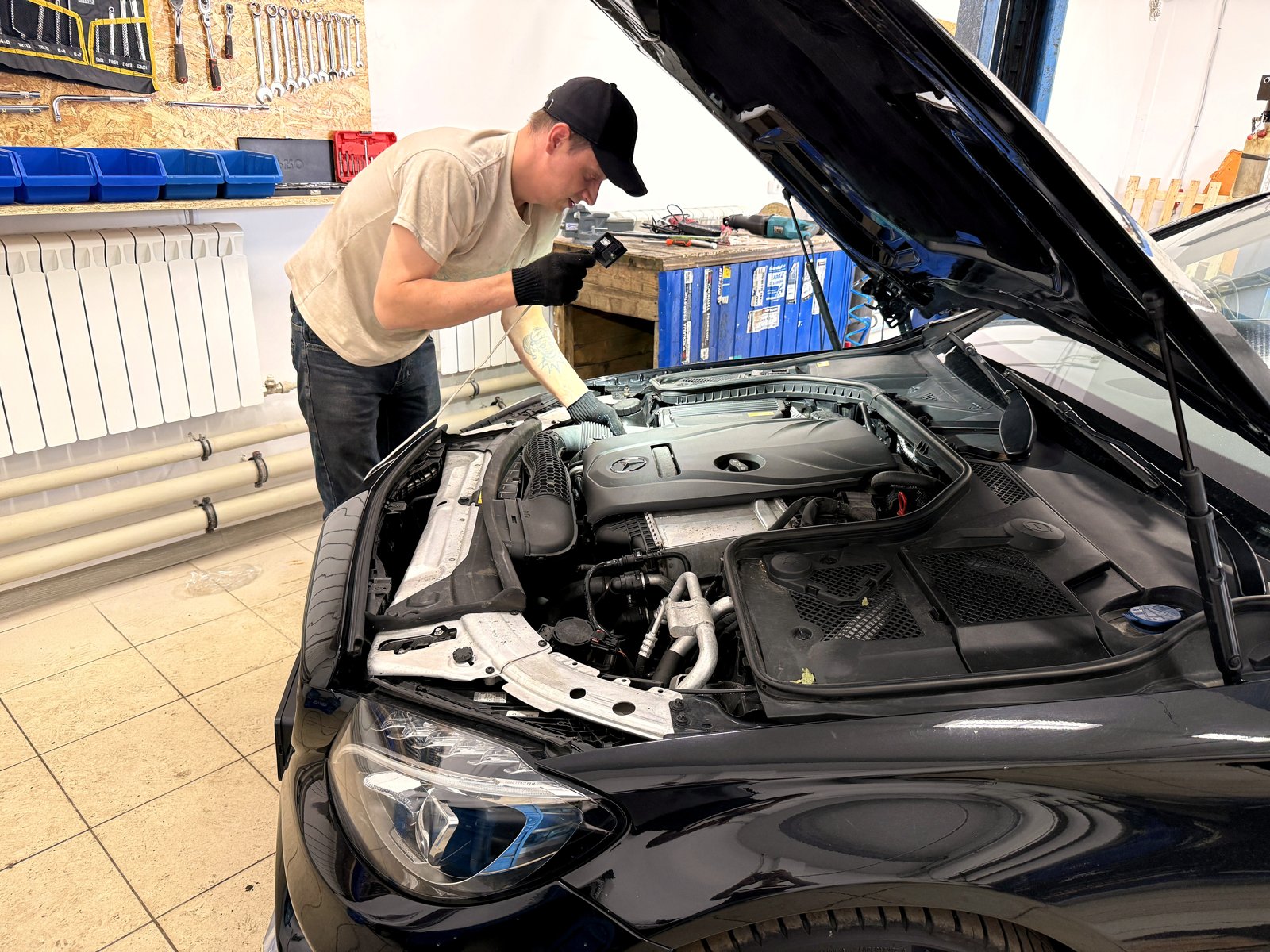 Мастер «Выхлопухи» проводит диагностику Mercedes с открытым капотом