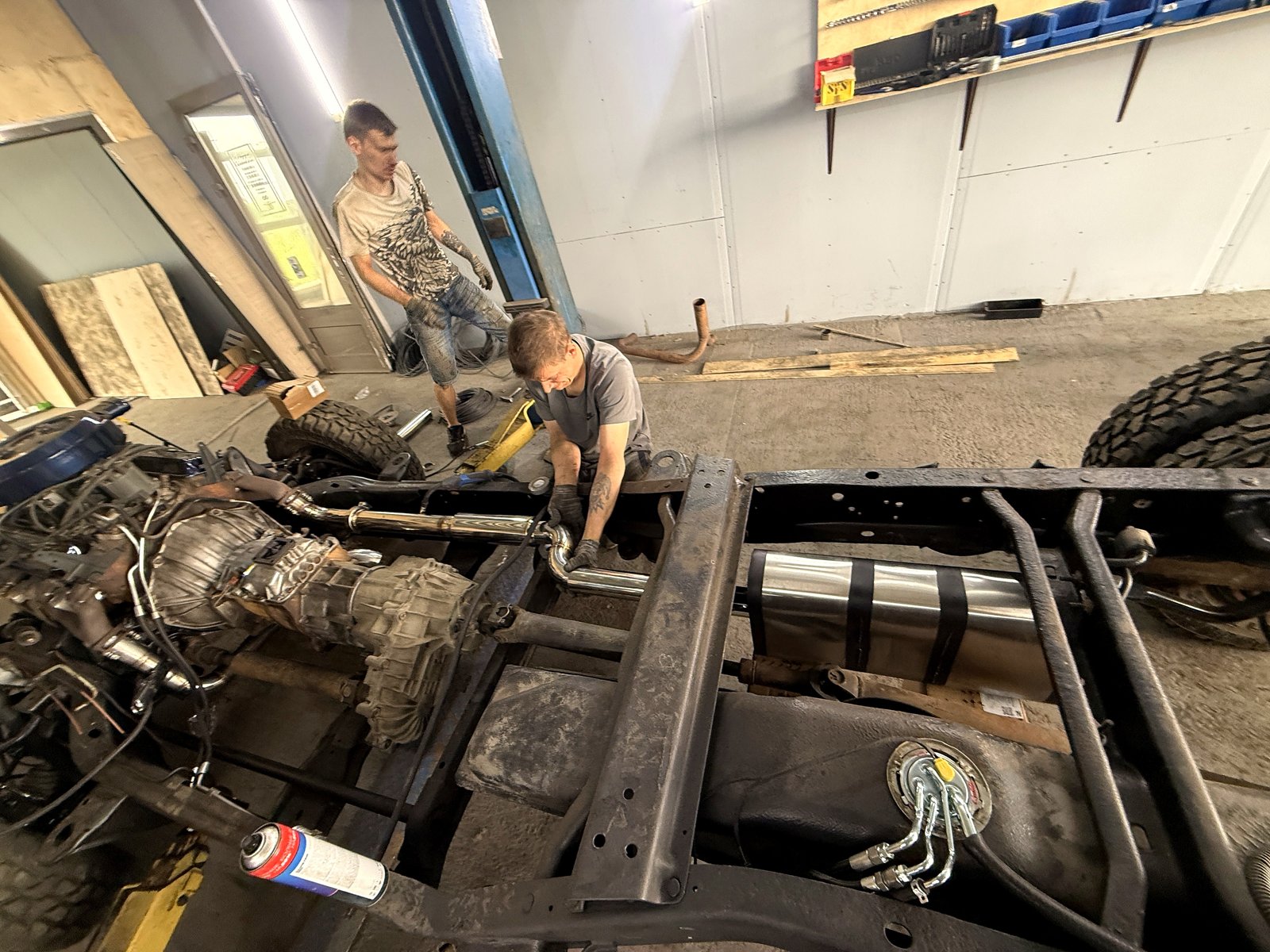 Мастер подгоняет трубу из нержавейки на раме эвакуатора, банка MG Race уже стоит внутри рамы рядом с баком
