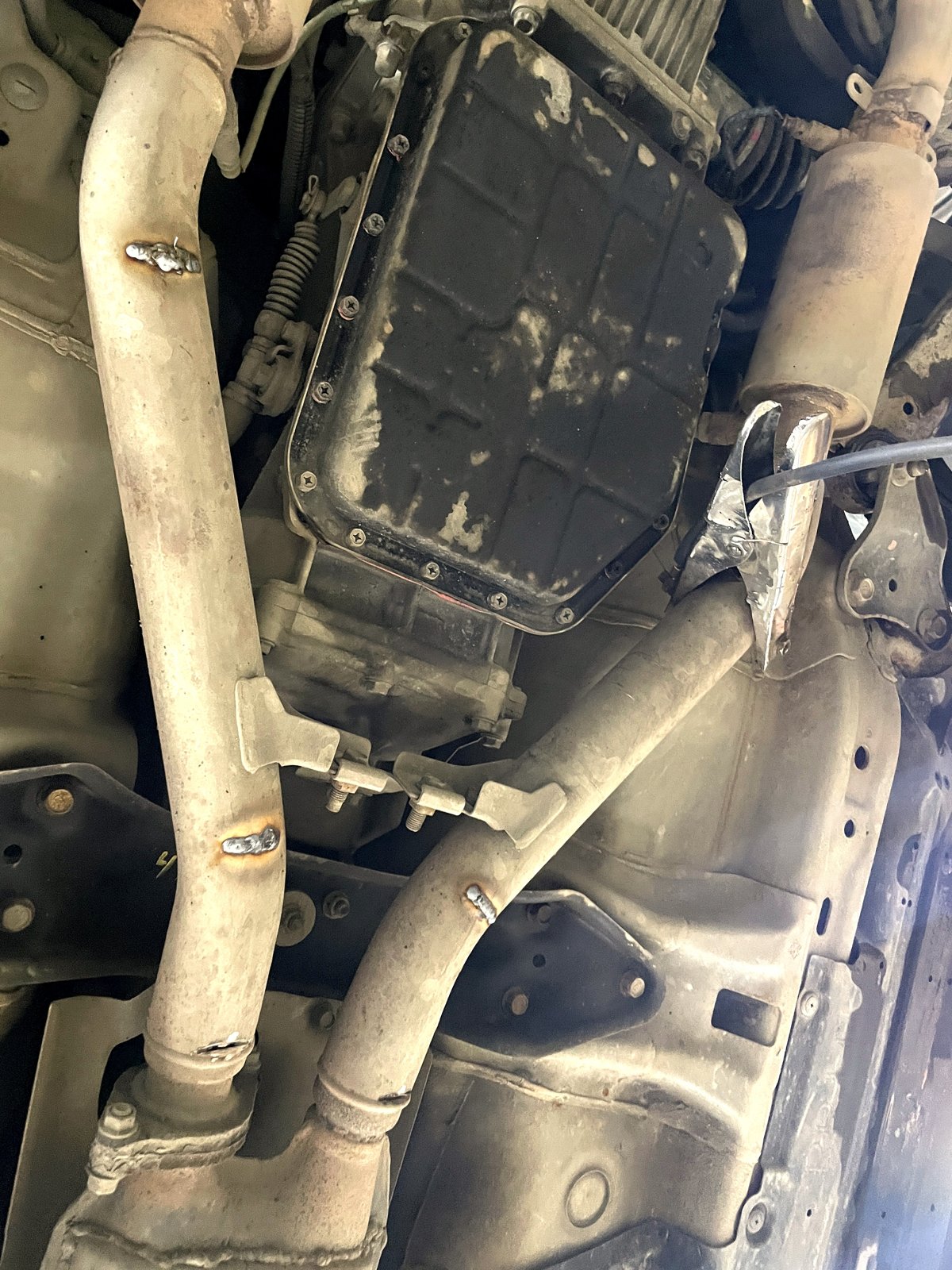 Приёмная труба Subaru Outback снизу: короткие свежие швы по прорезям, которыми соединили слои двустенной трубы