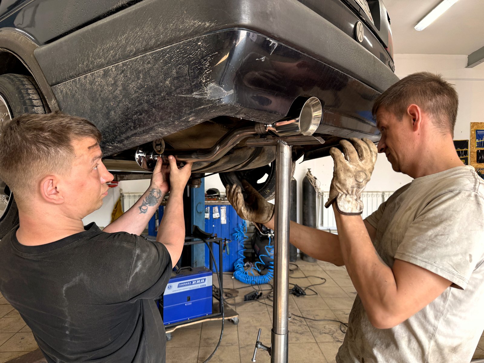 Готовая насадка выхлопа выведена под задним бампером Volkswagen Golf IV, видна эмблема VW на крышке багажника