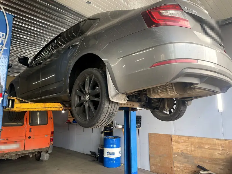 Škoda Octavia поднята на подъёмнике, вид сзади: задняя банка уже снята, под бампером пустое место