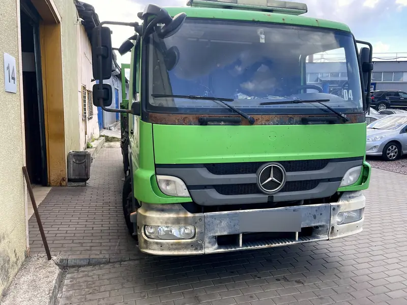 Зелёный грузовой Mercedes с манипулятором стоит у бокса «Выхлопухи» на Южном шоссе, вид спереди